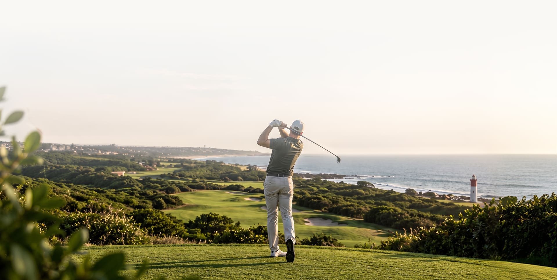 Golfer teeing off above the Umhlanga coastline and lighthouse